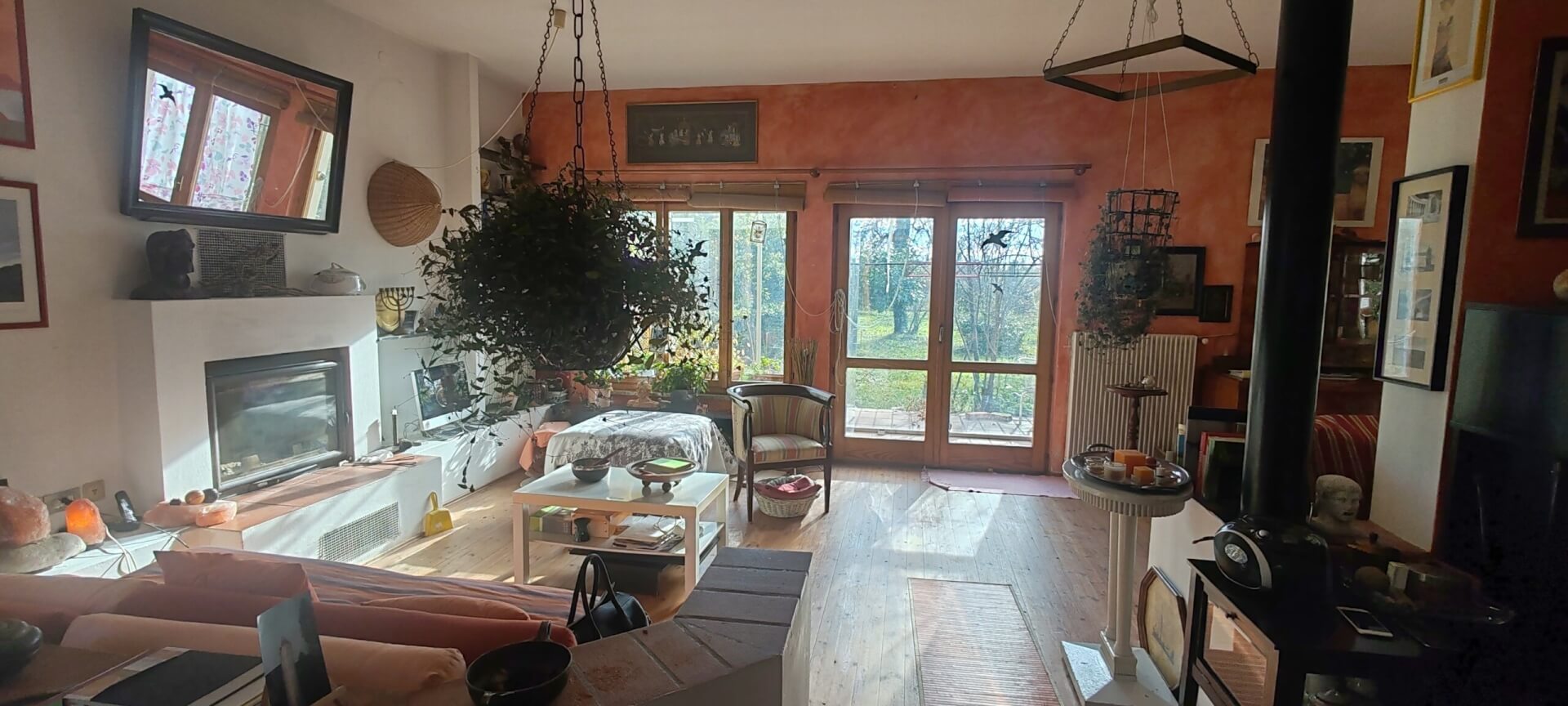 Ansicht Wohnzimmer mit Kaminecke und Terrassenfenstern