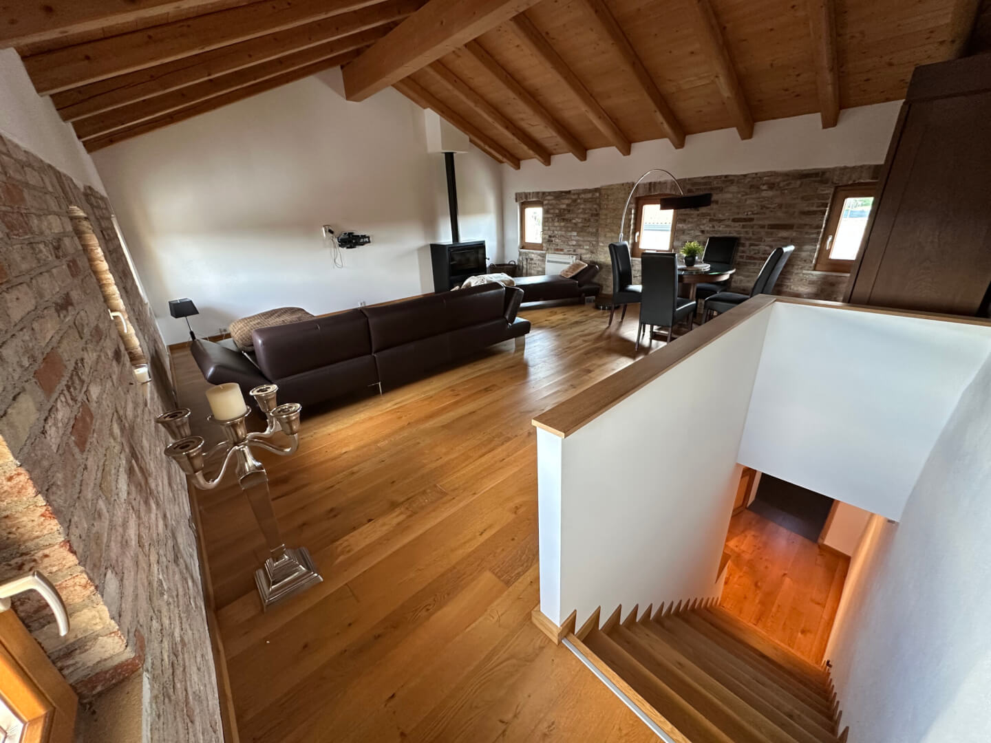 Großzügiger Wohnbereich im Dachgeschoss, mit viel Liebe zum Detail gestaltet und mit sichtbaren Natursteinwänden und Holzkamin